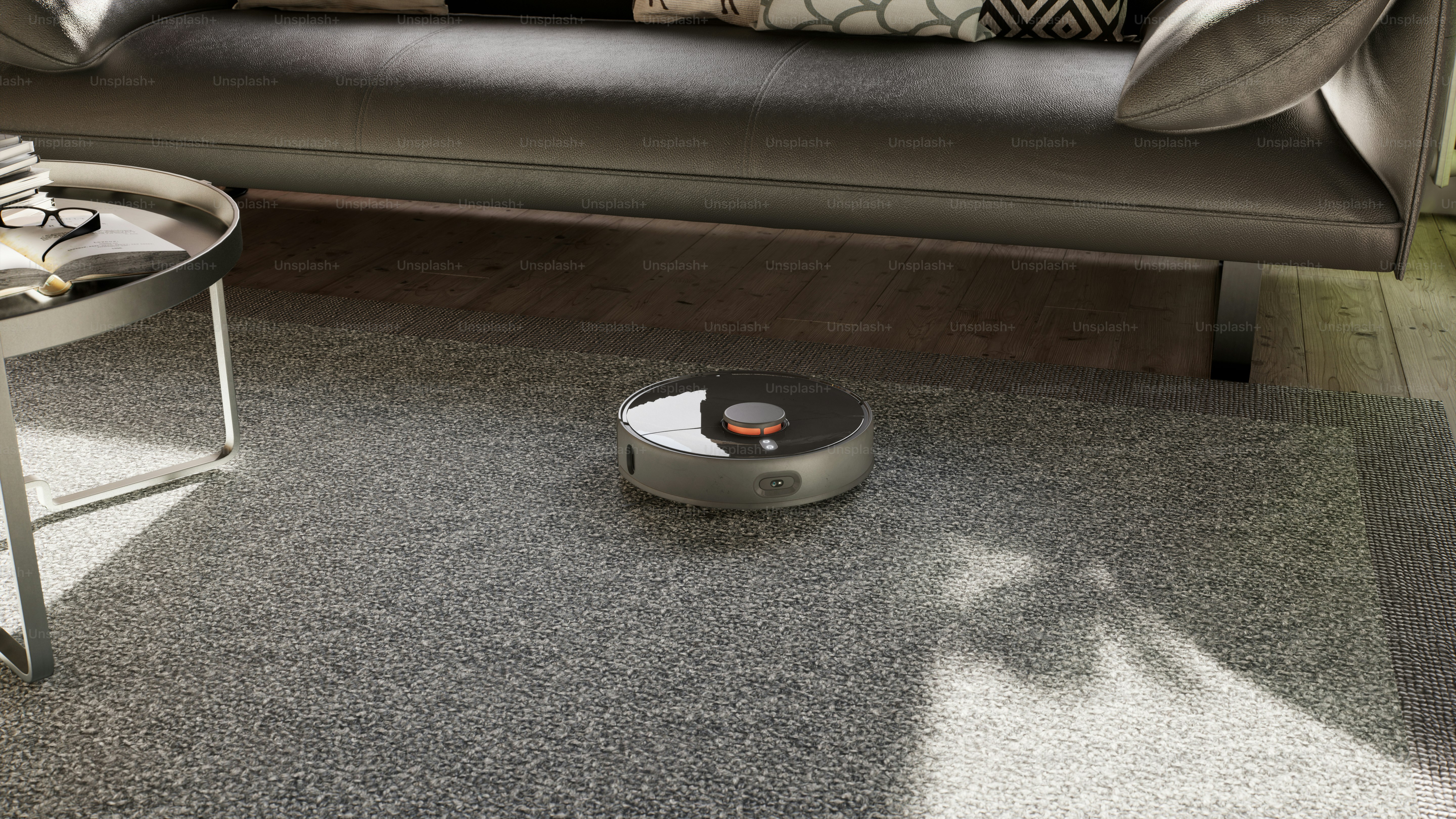 a roomba sits on the floor in front of a couch