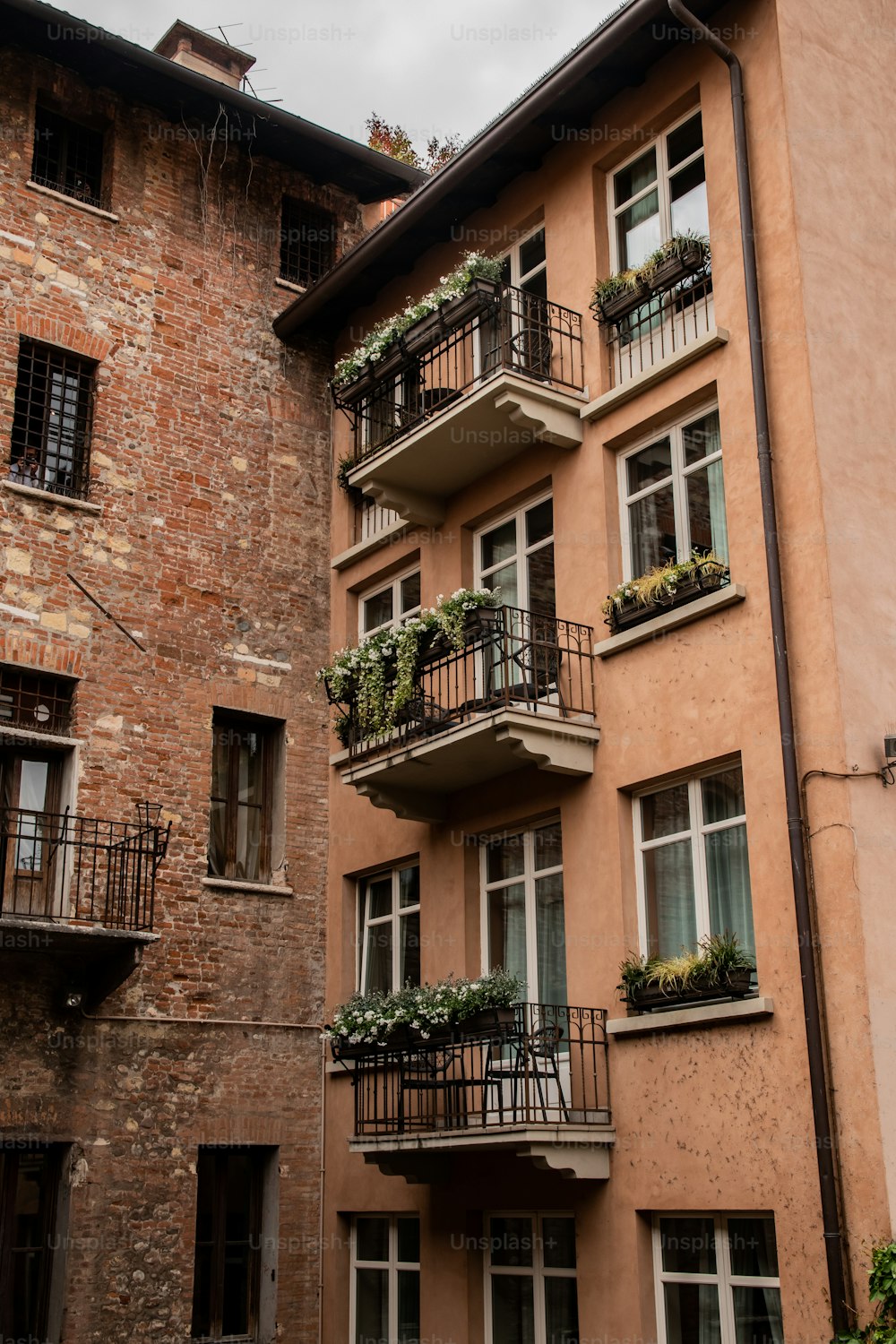 a tall building with balconies and plants on the balconies