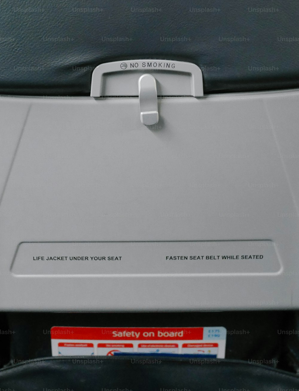 um assento em um avião com um botão de segurança
