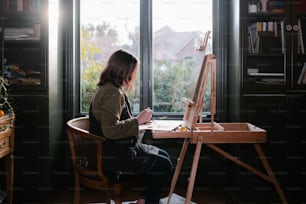 a woman sitting at a desk in front of a window