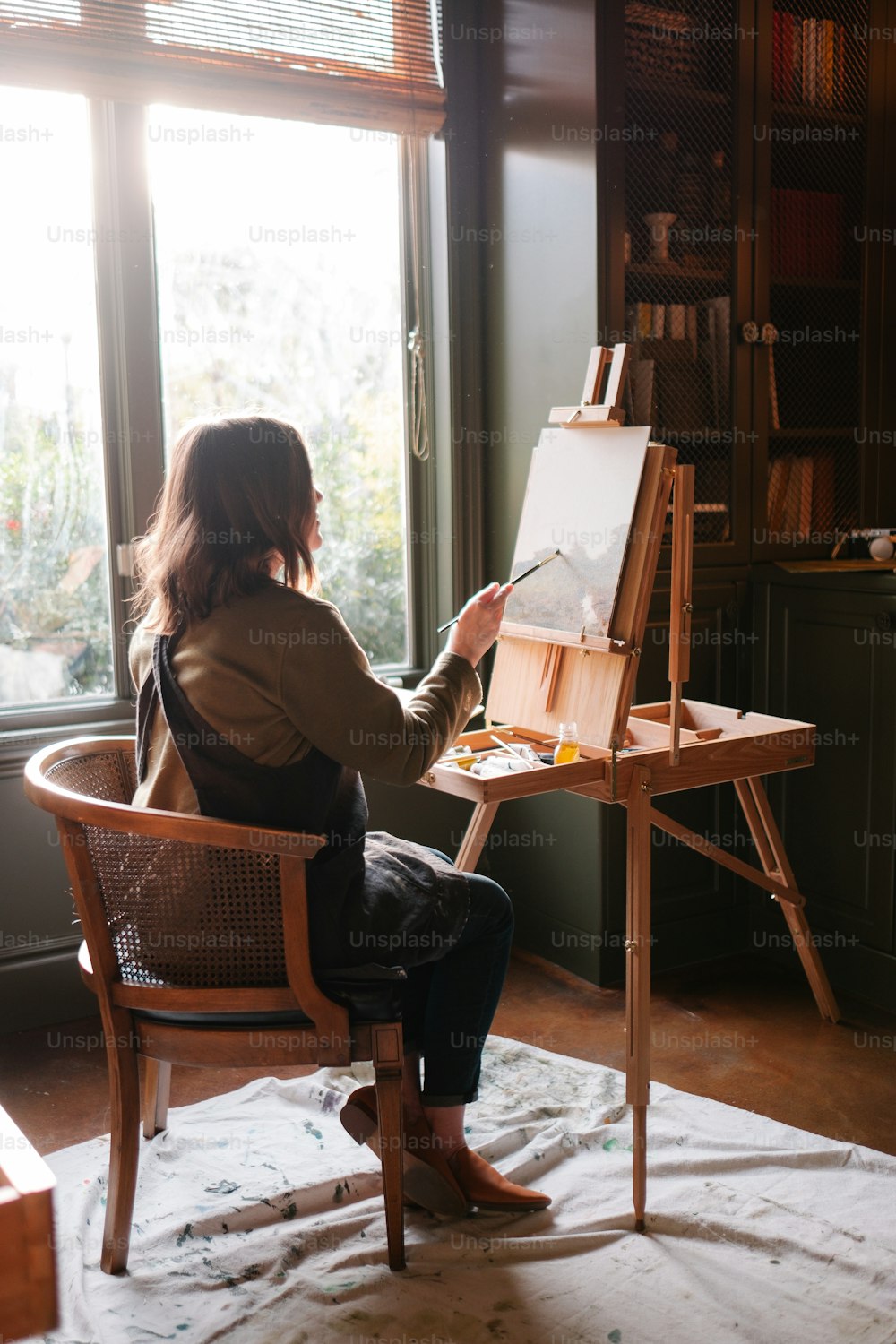 a woman sitting in a chair in front of a painting