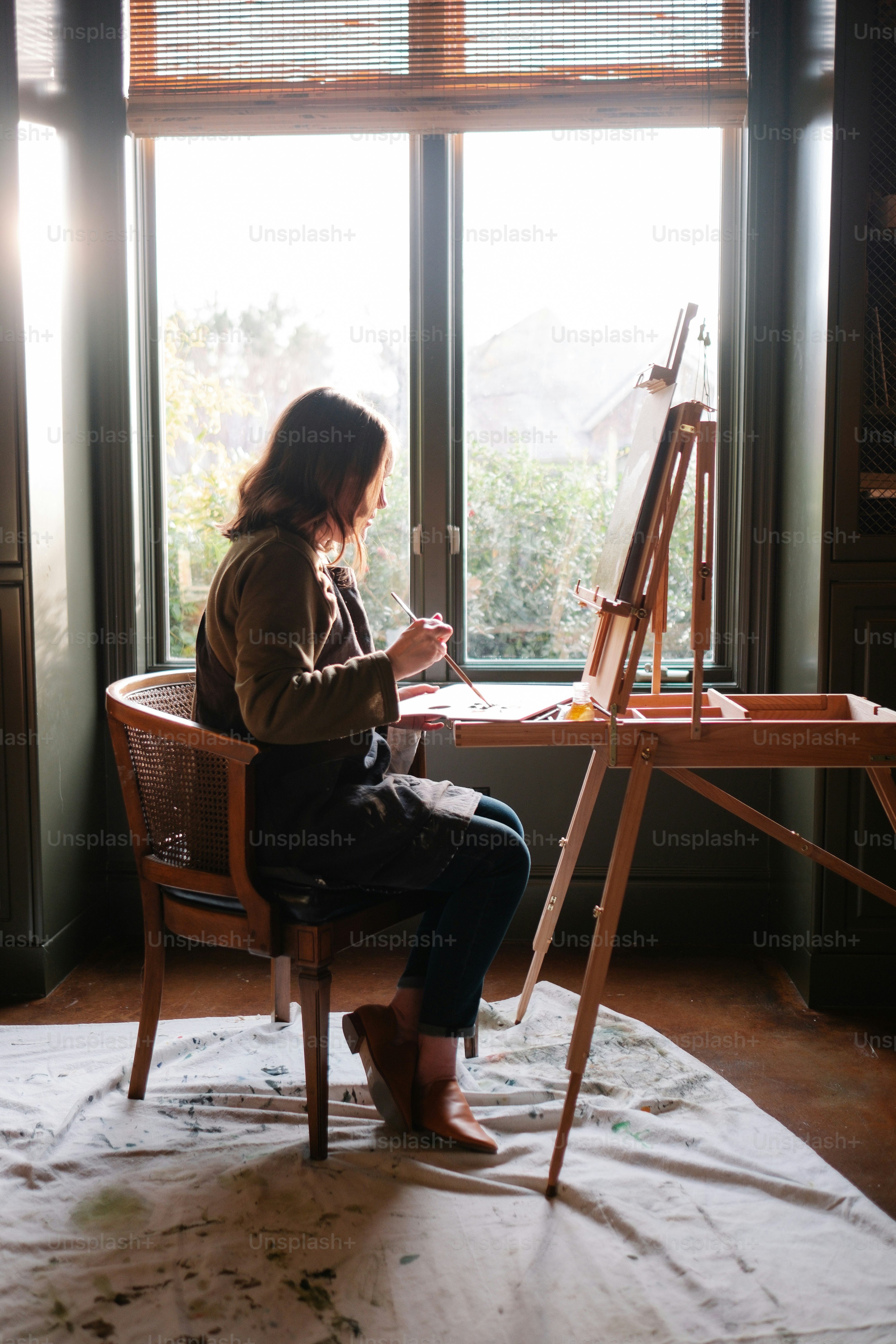 Eine Frau sitzt auf einem Stuhl vor einem Fenster