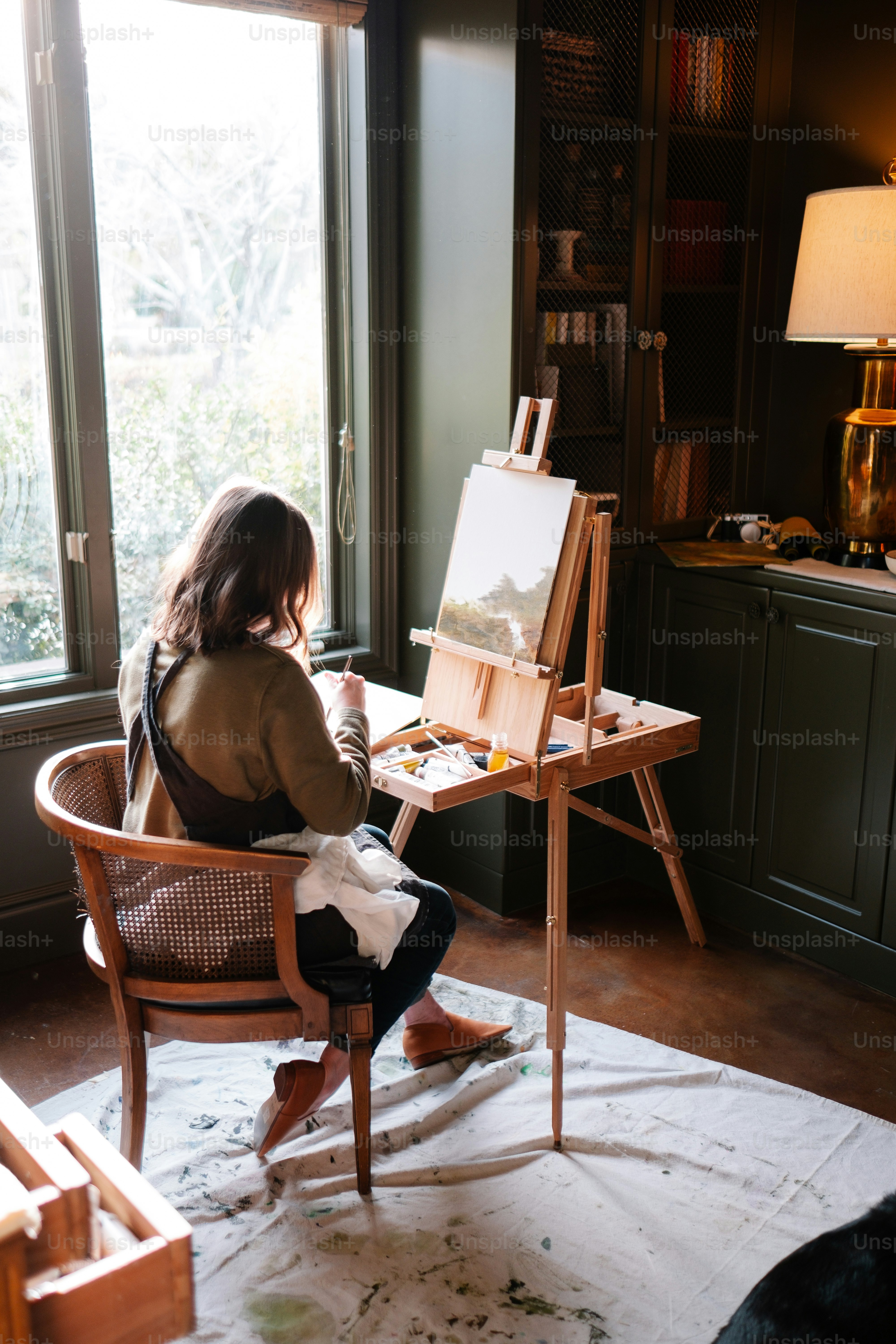 Une femme assise sur une chaise devant un tableau