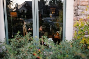 Eine Frau, die sich durch ein Fenster fotografiert