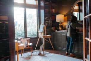 a woman standing in a room next to a window