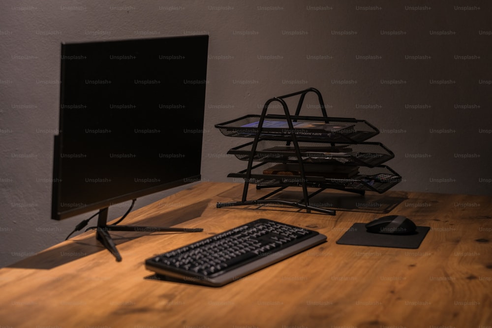 un monitor di computer seduto sopra una scrivania di legno
