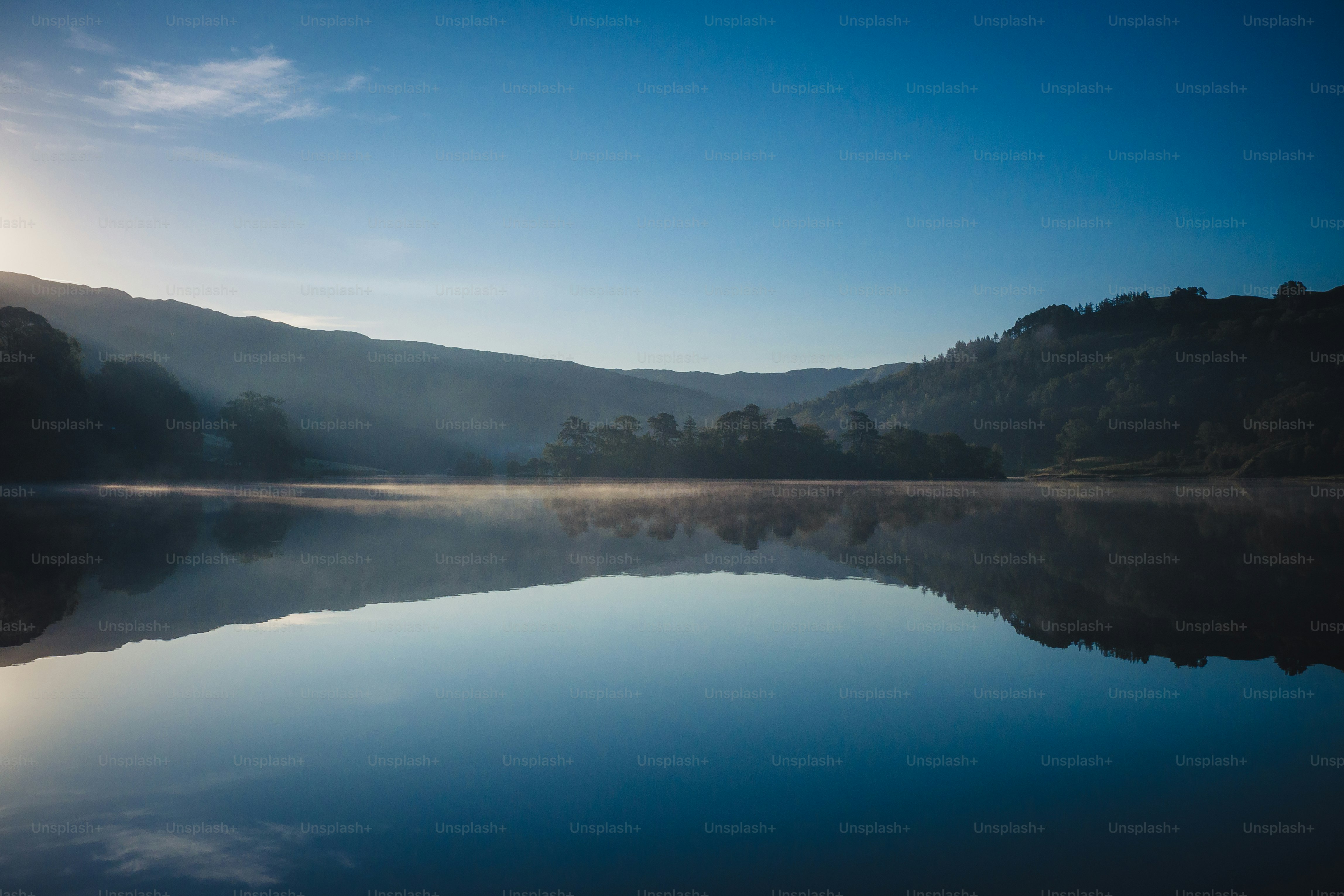ein großes Gewässer, umgeben von Bergen