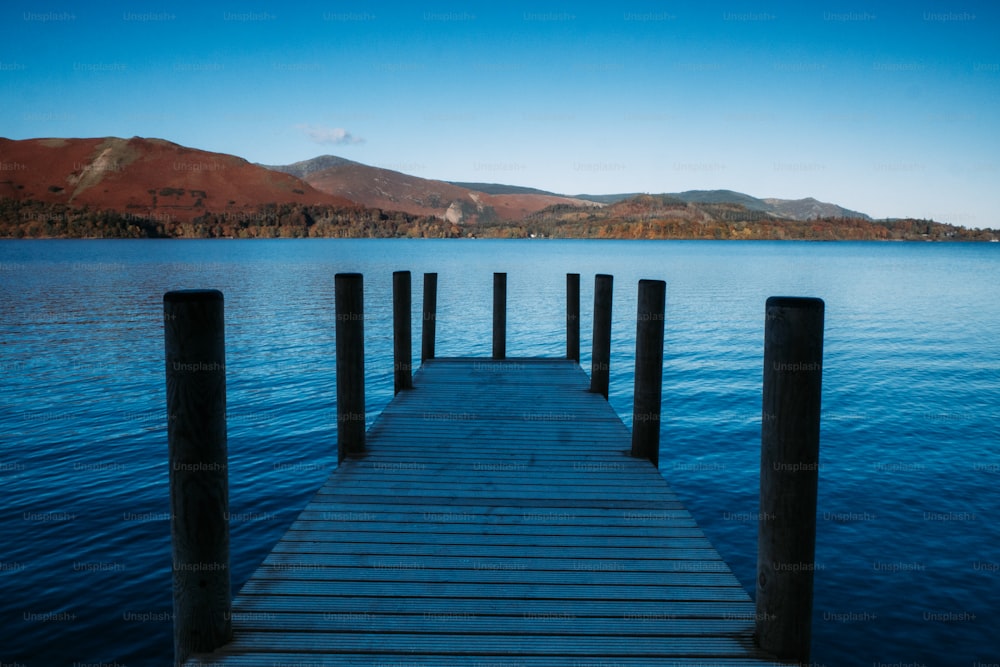 a dock on a lake with mountains in the background