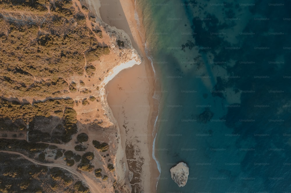 Una vista aérea de una playa con un barco en el agua