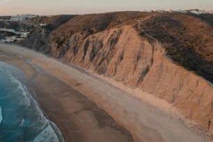 uma vista aérea de uma praia de areia e um penhasco