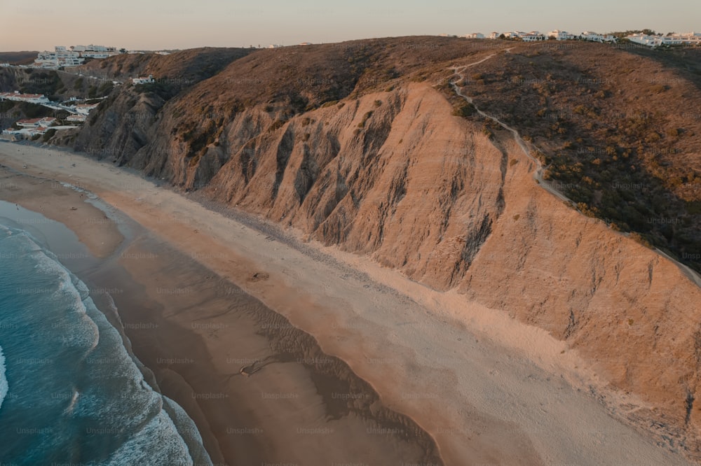 an aerial view of a sandy beach and a cliff