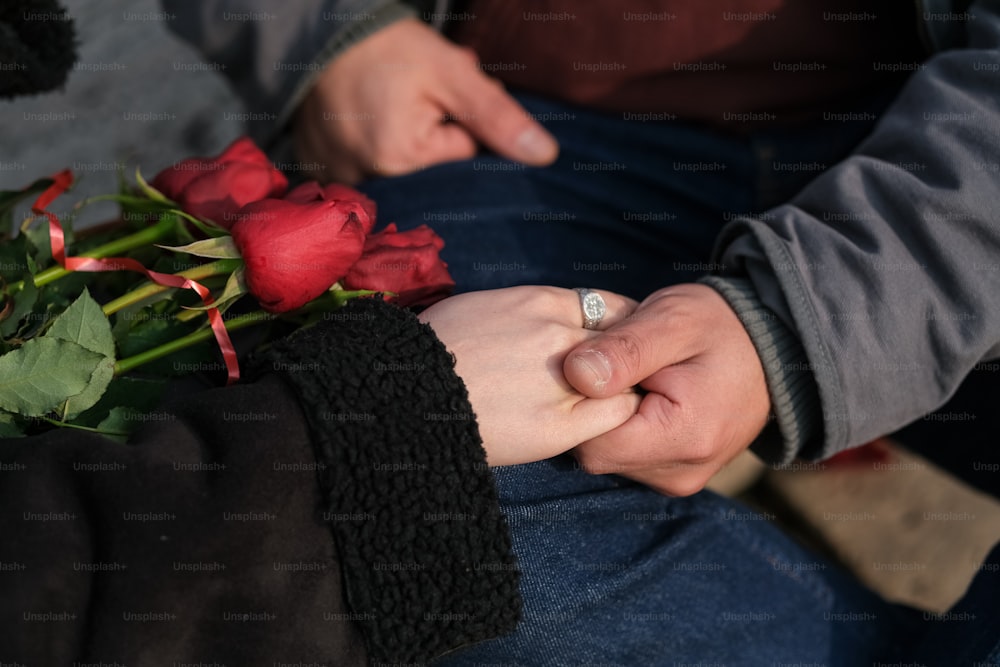 a close up of two people holding hands