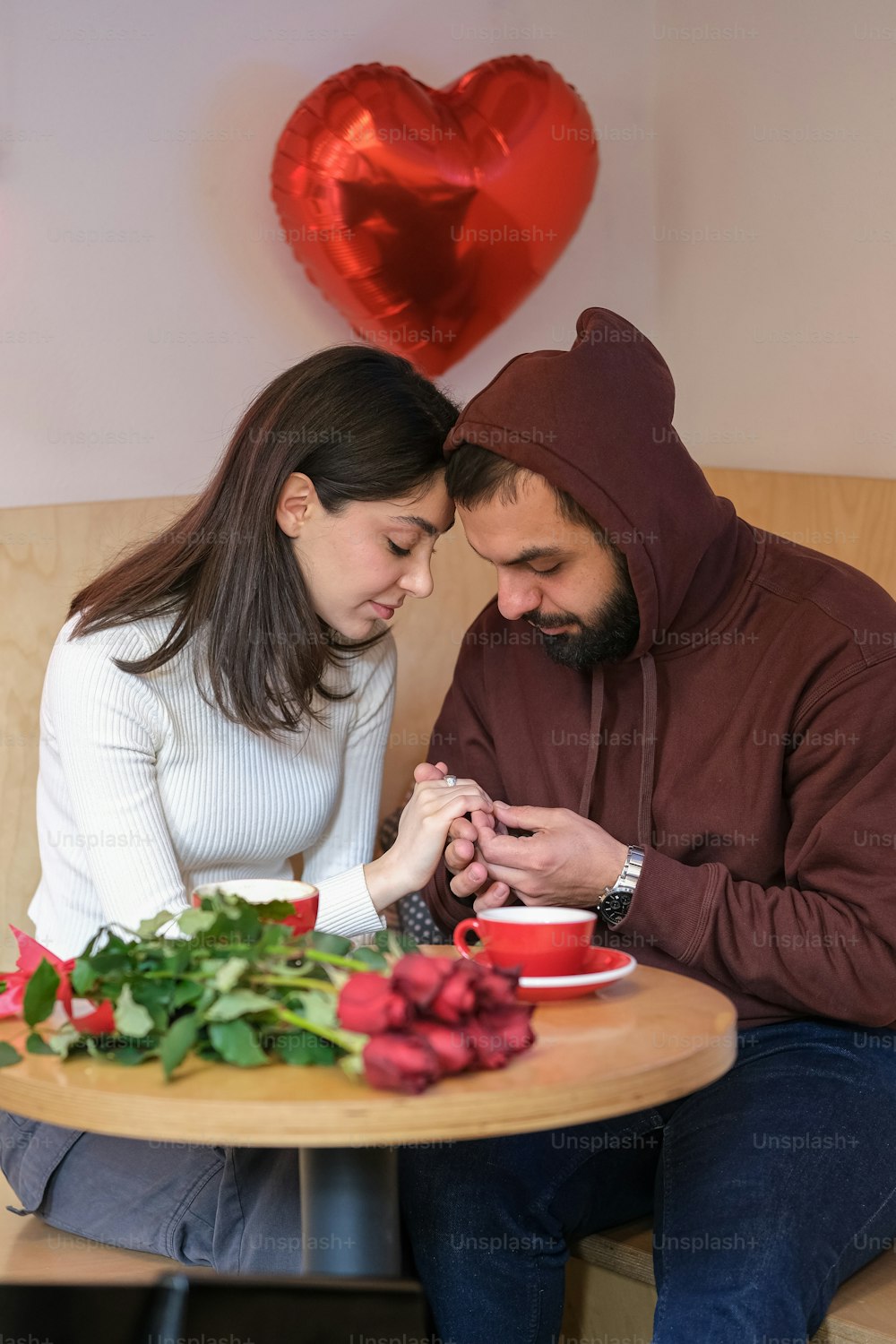 Un homme et une femme assis à une table regardant un téléphone portable