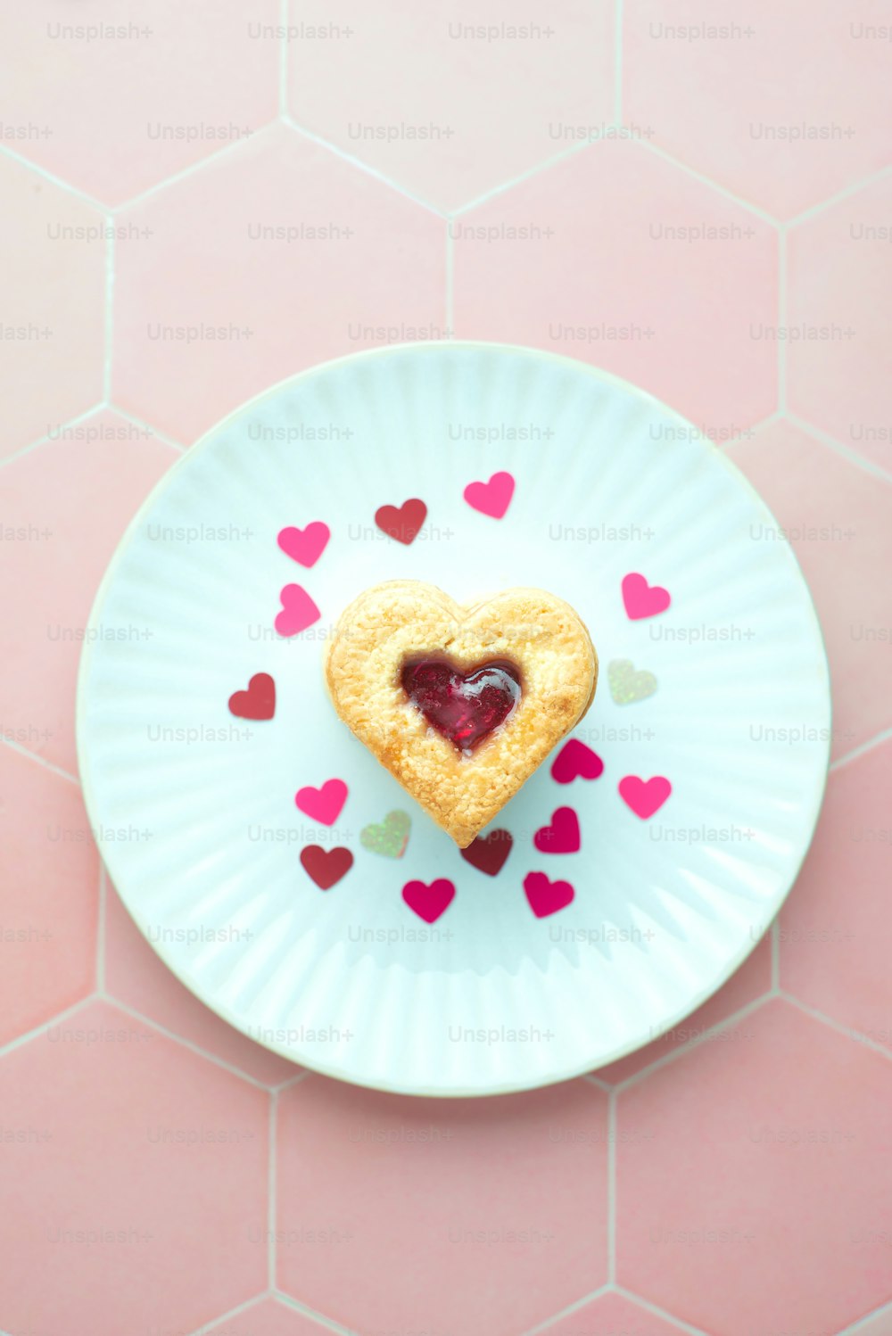 un biscuit en forme de cœur sur une assiette avec des cœurs dessus