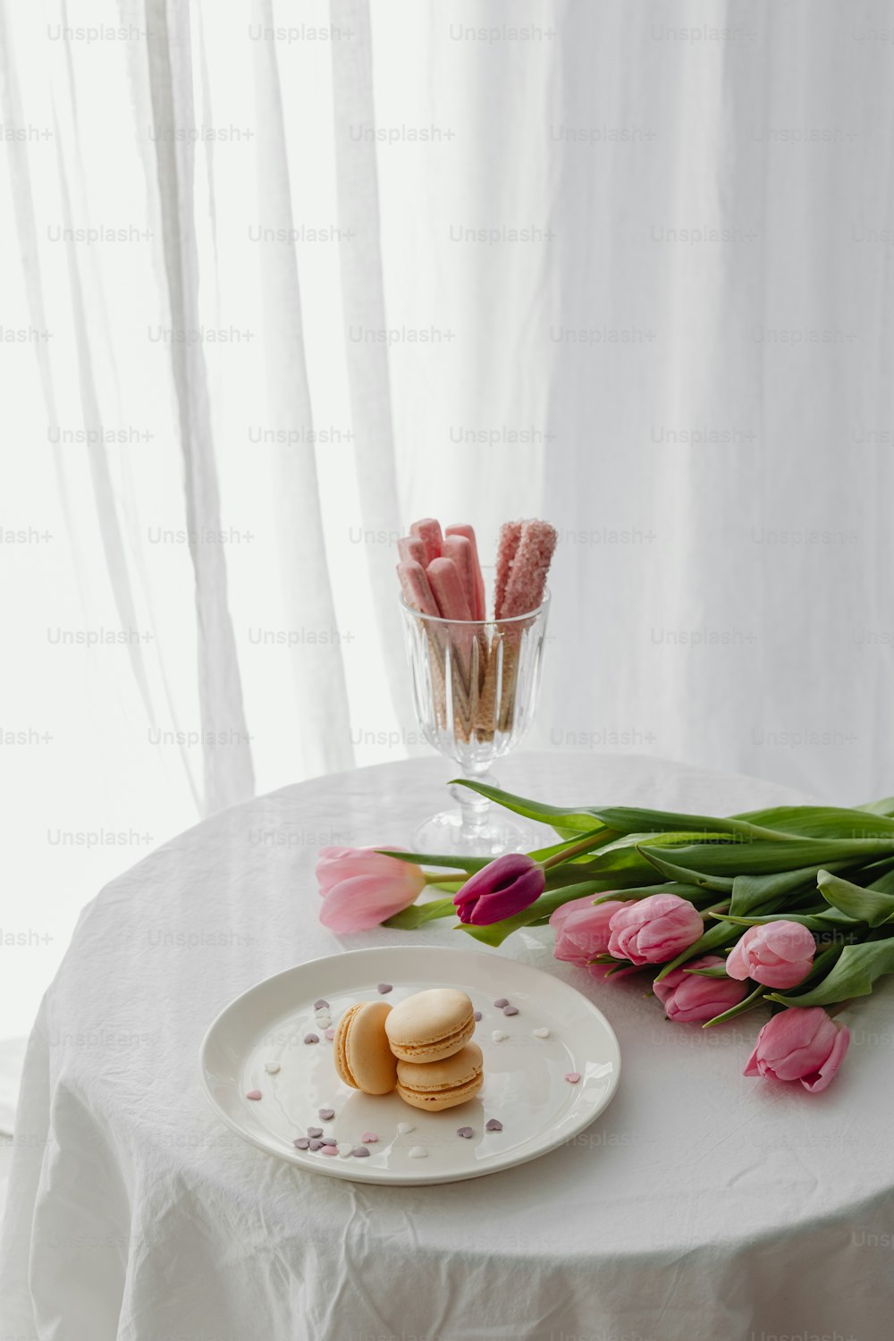 une assiette de biscuits et de tulipes roses sur une table