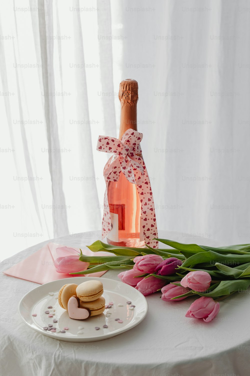 a table topped with a bottle of wine and flowers
