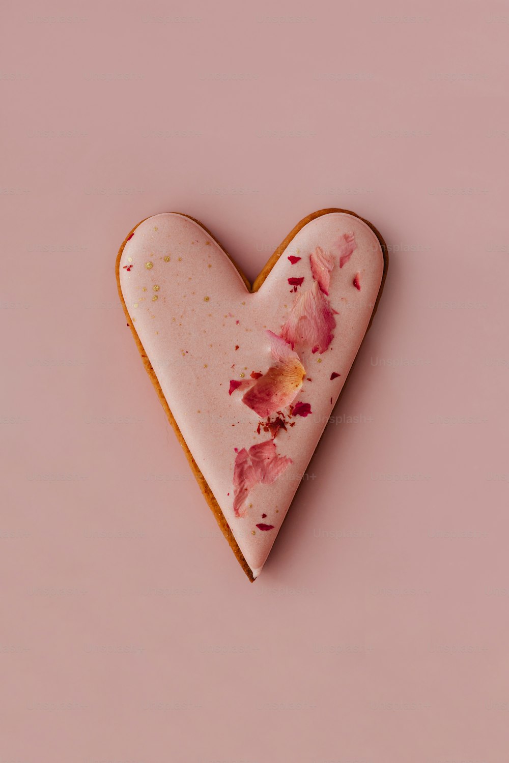 um biscoito em forma de coração com flores cor-de-rosa sobre ele