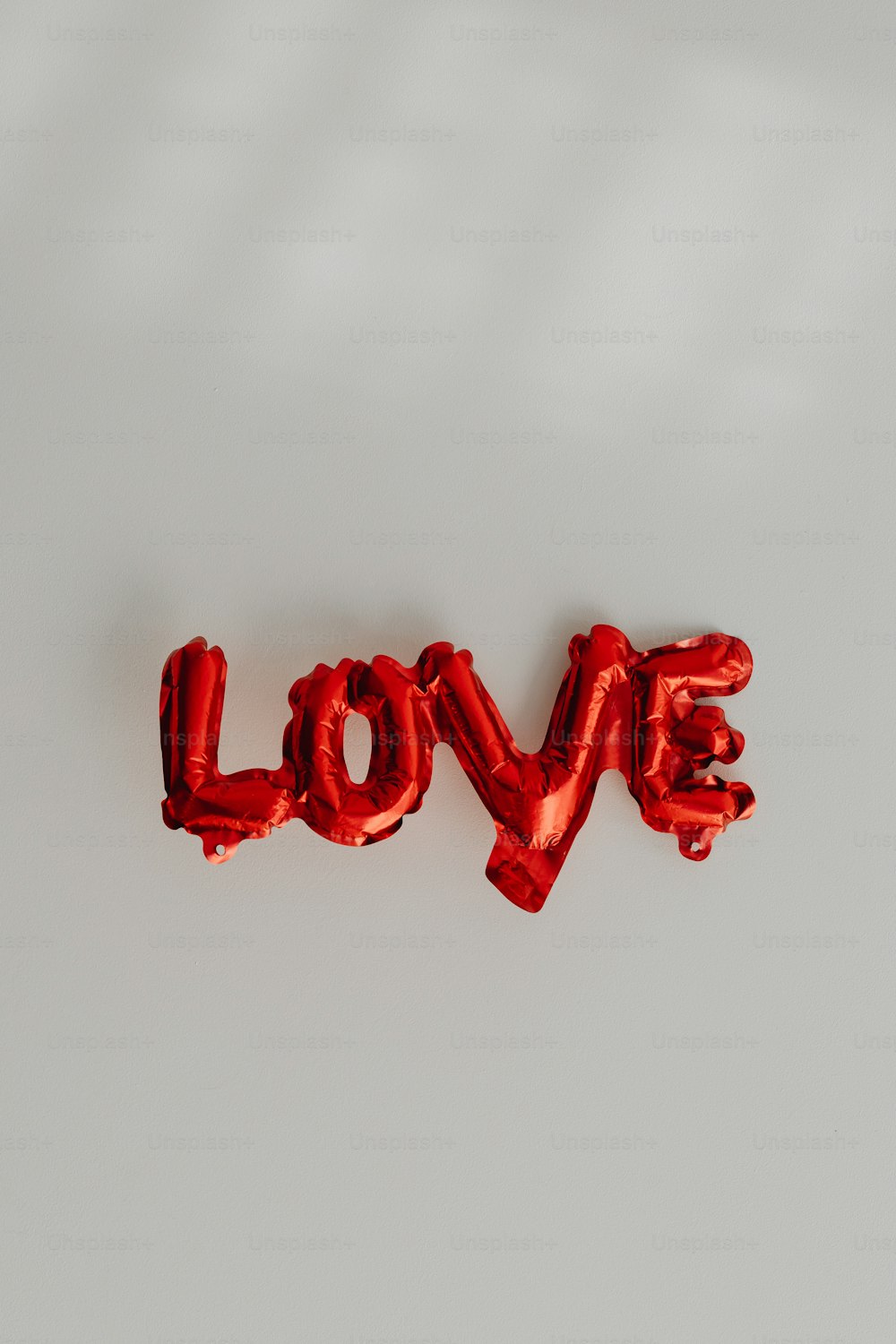 the word love spelled with red foil balloons
