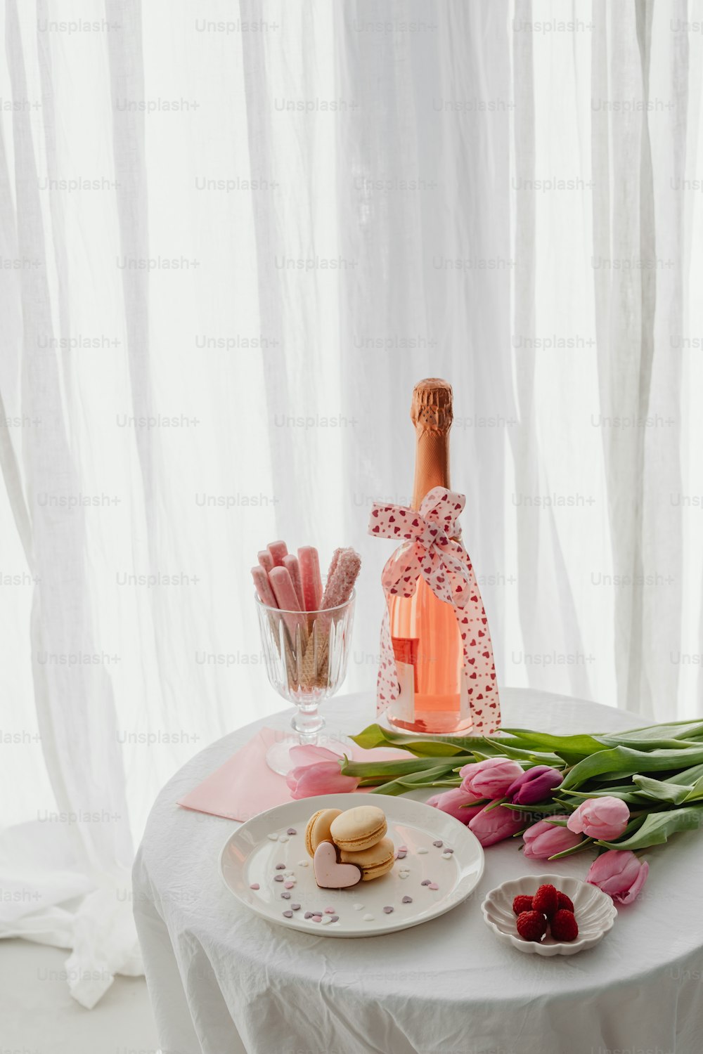 a table topped with a bottle of wine and a plate of food