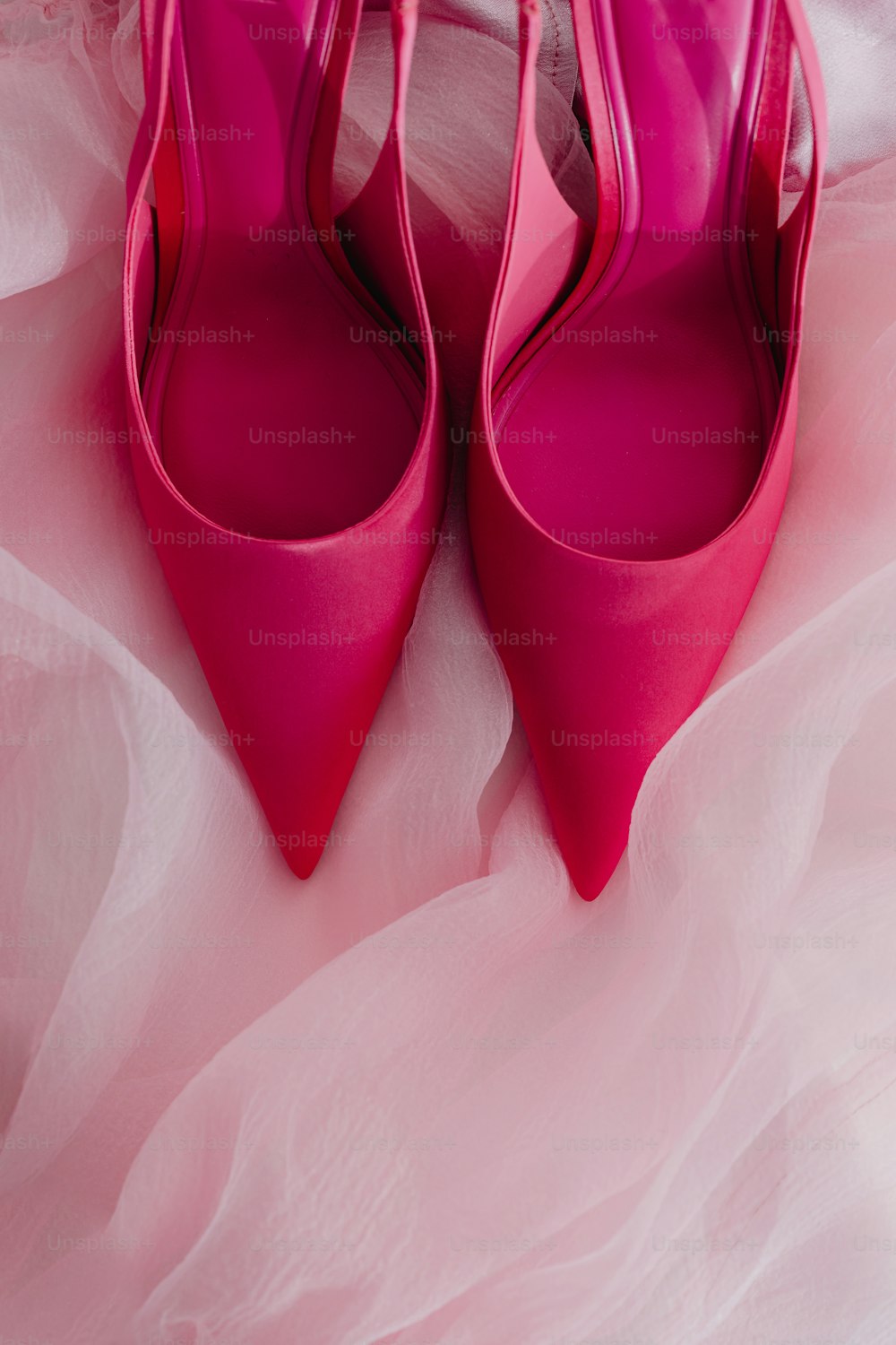 um par de sapatos cor-de-rosa sentados em cima de uma cama