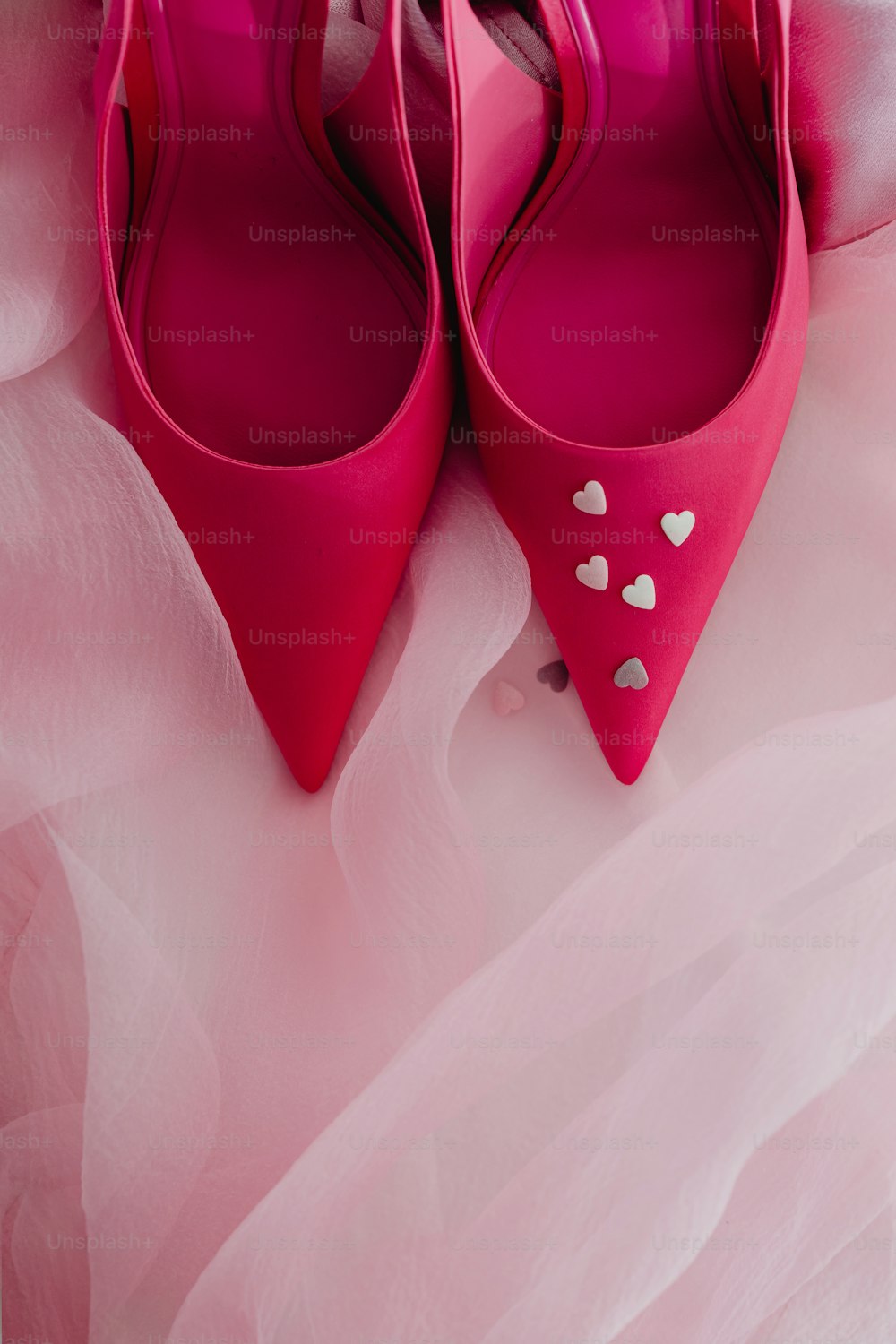 ein Paar rosa Schuhe mit Herzen darauf