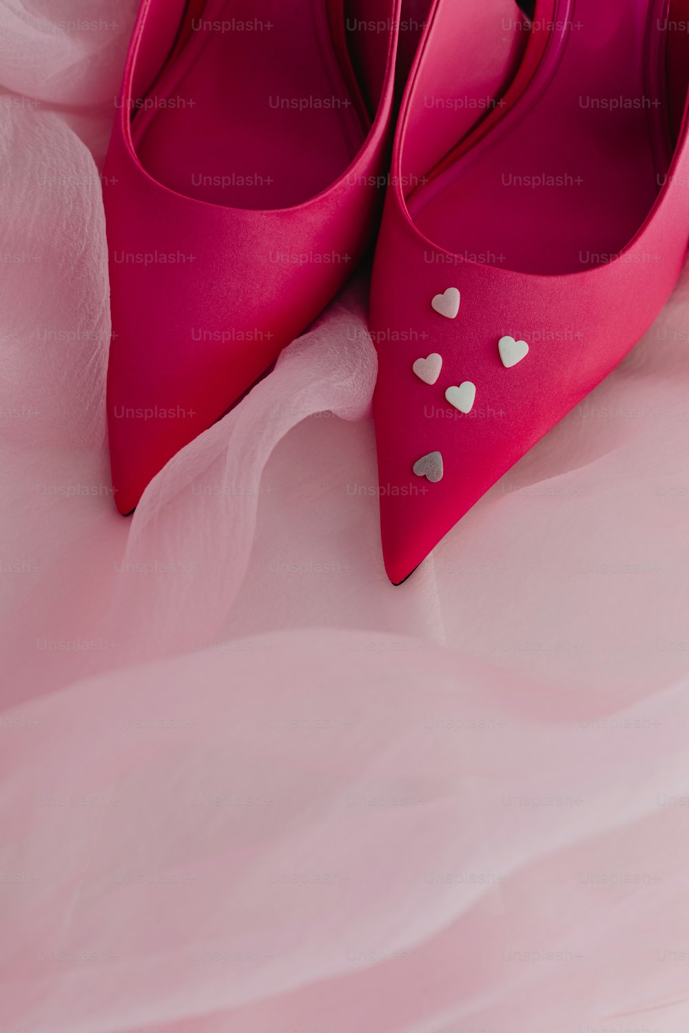 um par de sapatos cor-de-rosa com corações sobre eles