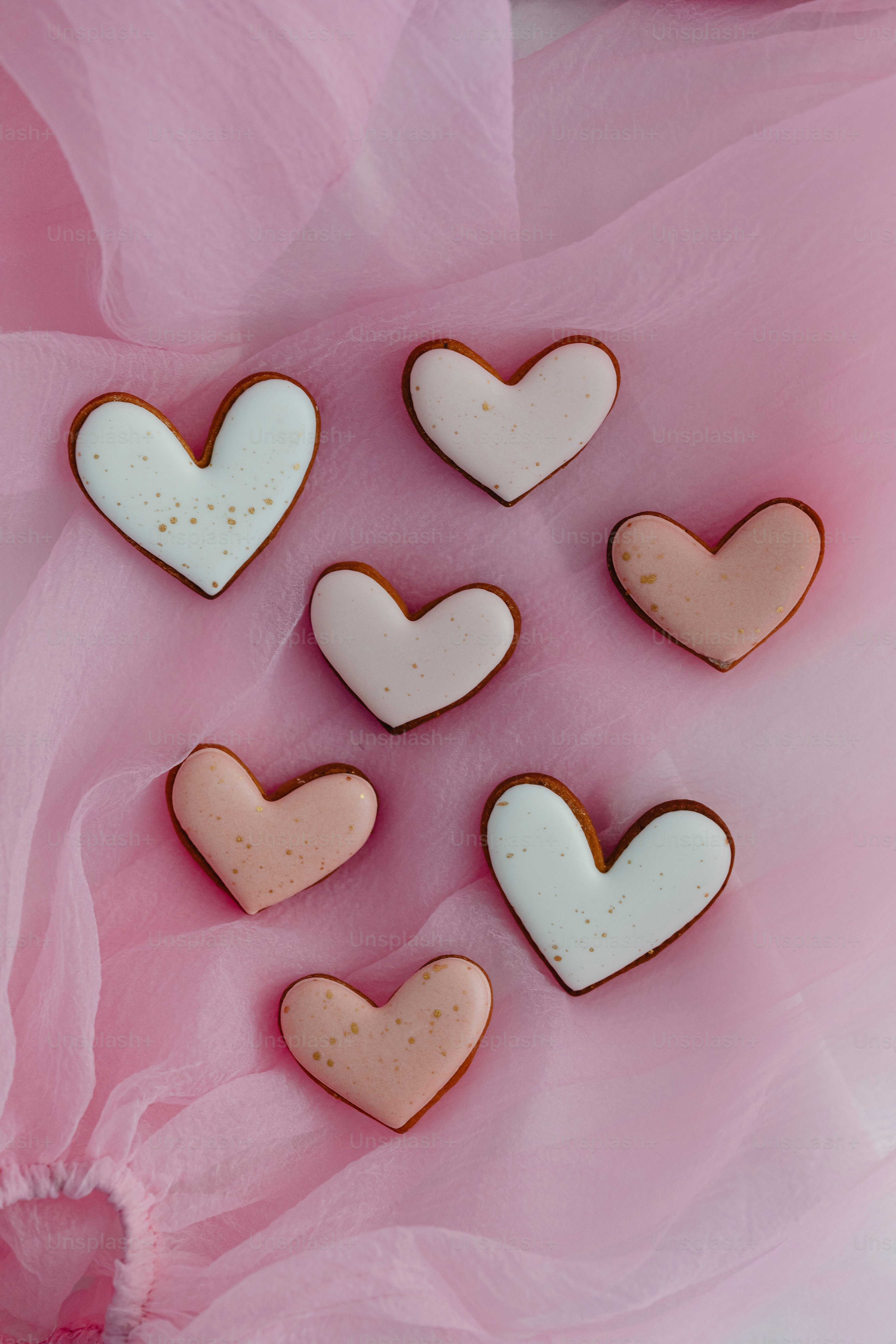 a bunch of heart shaped cookies sitting on top of a table