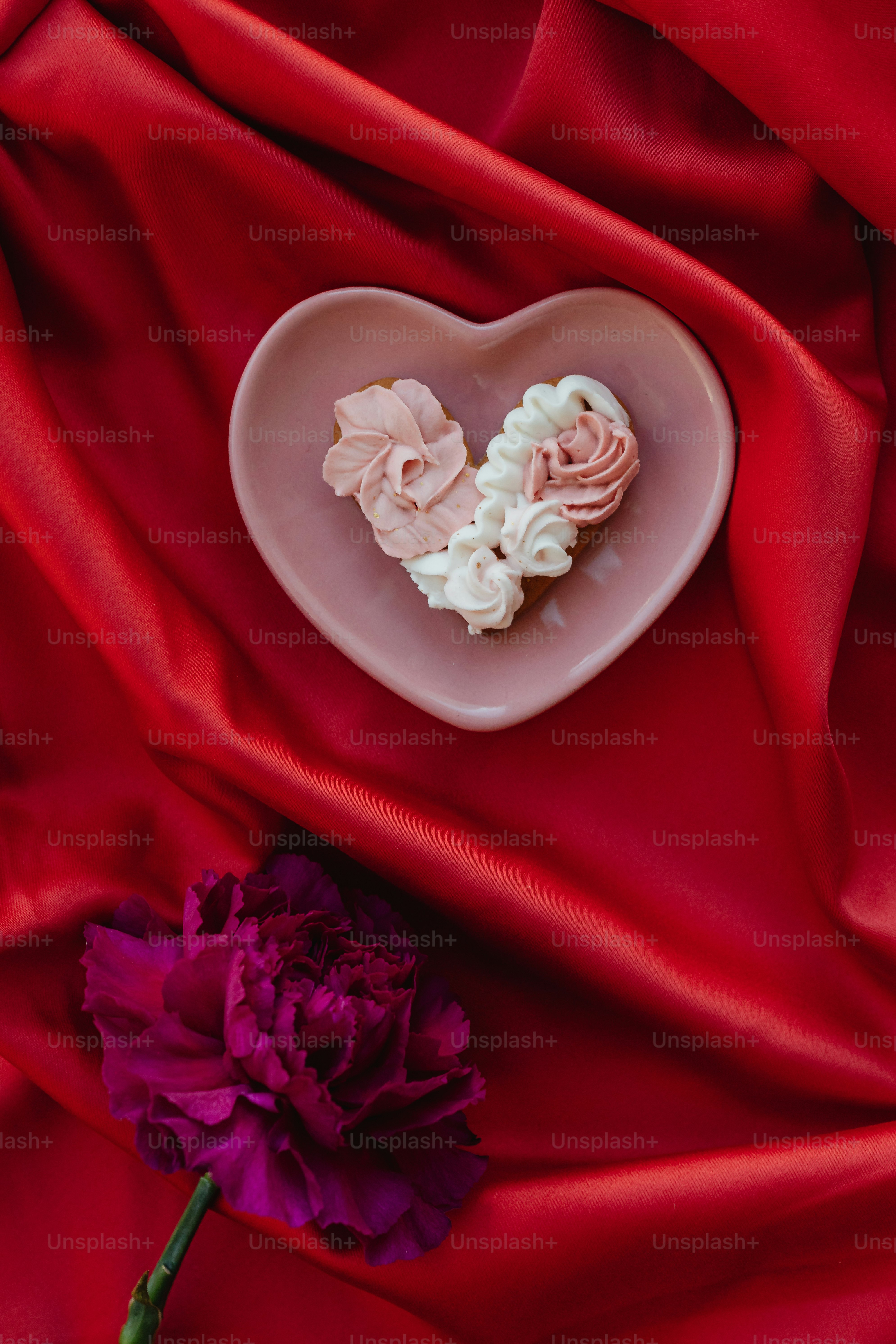 a heart shaped plate with flowers on a red cloth