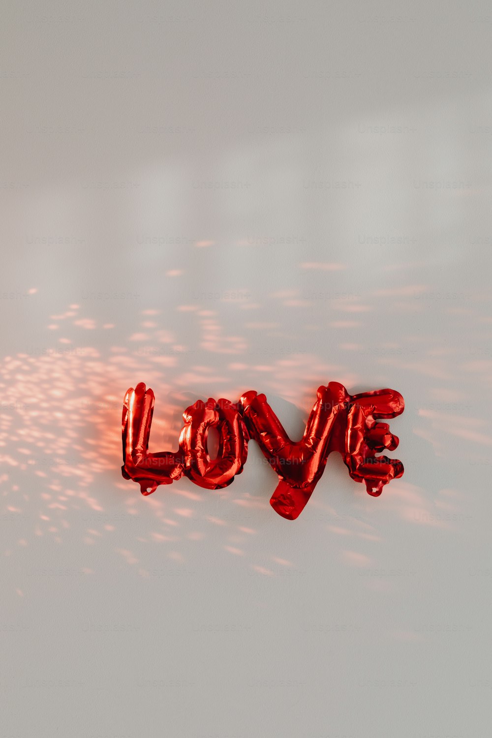 the word love spelled out of balloons on a white surface