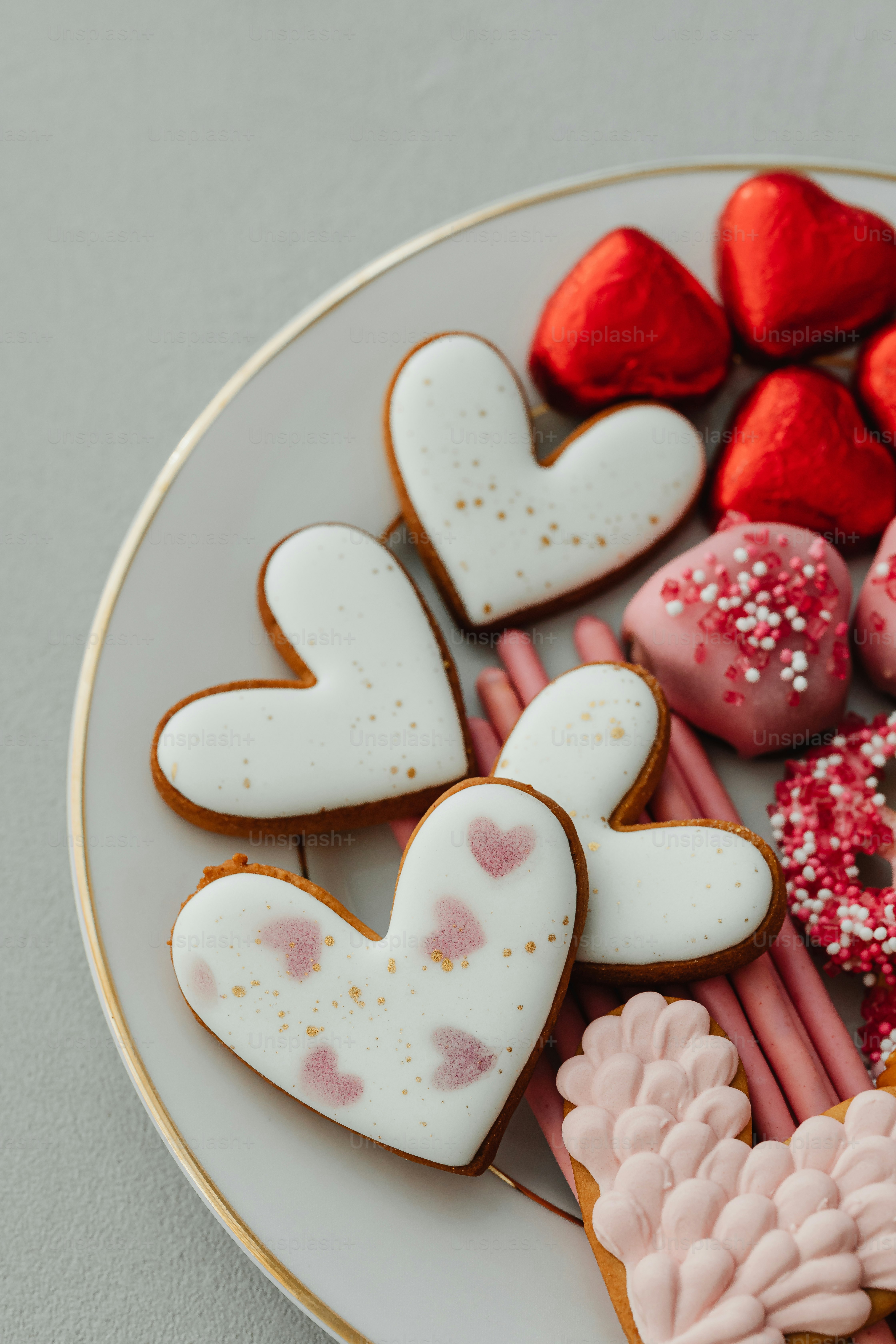 a white plate topped with lots of heart shaped cookies