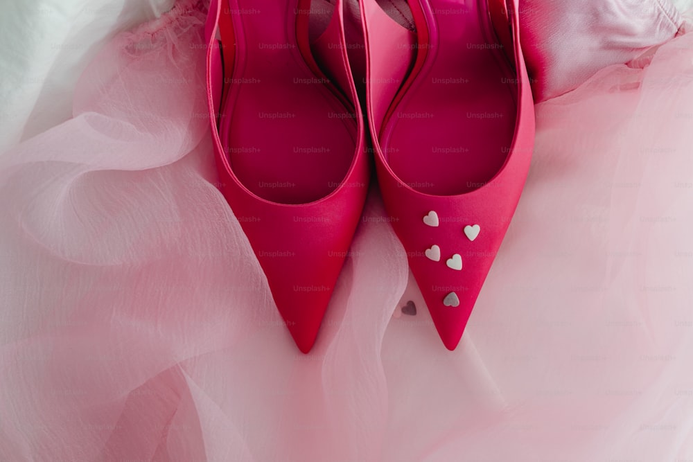 ein Paar rosa Schuhe mit Herzen darauf