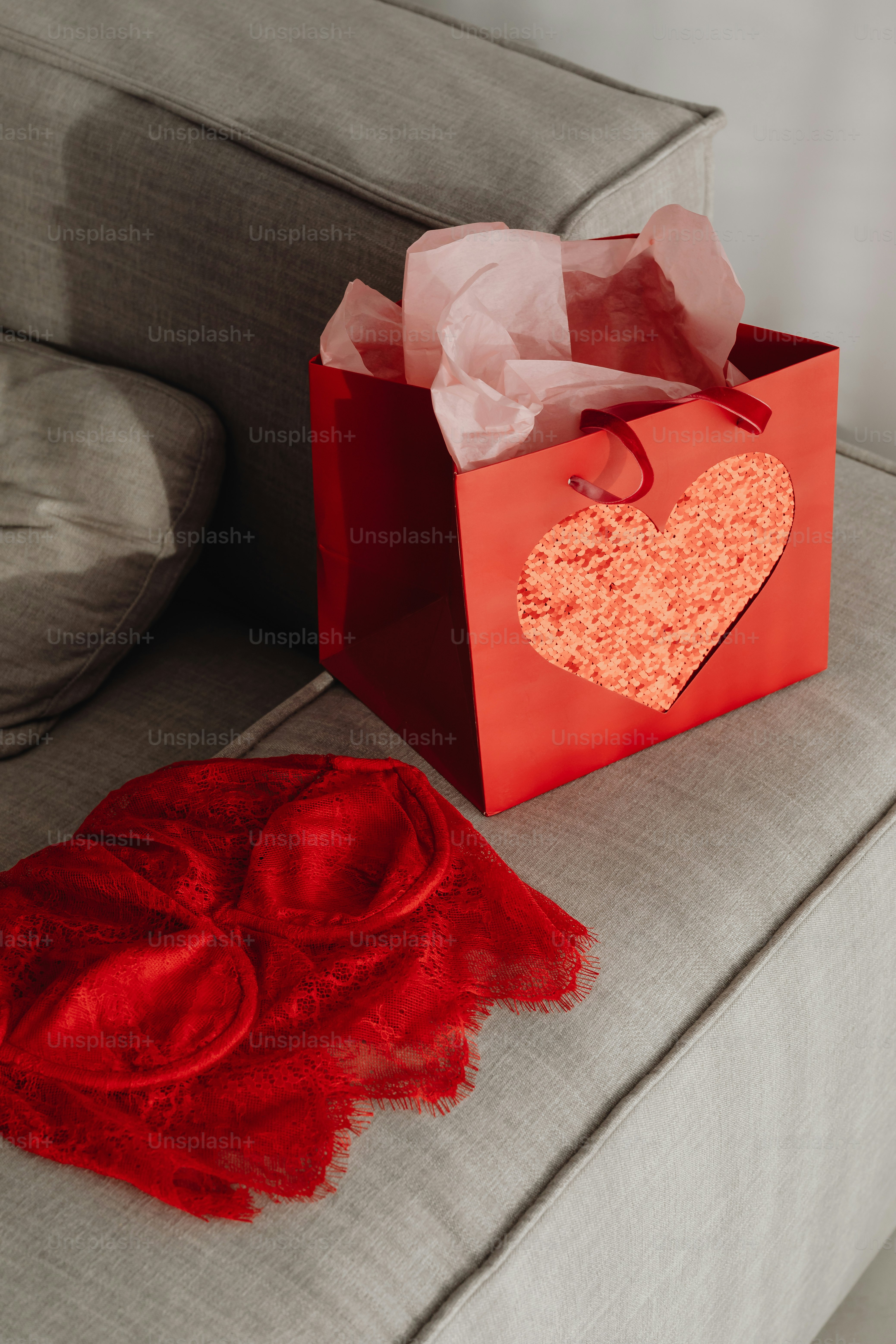 una borsa rossa con un cuore su di esso seduto su un divano