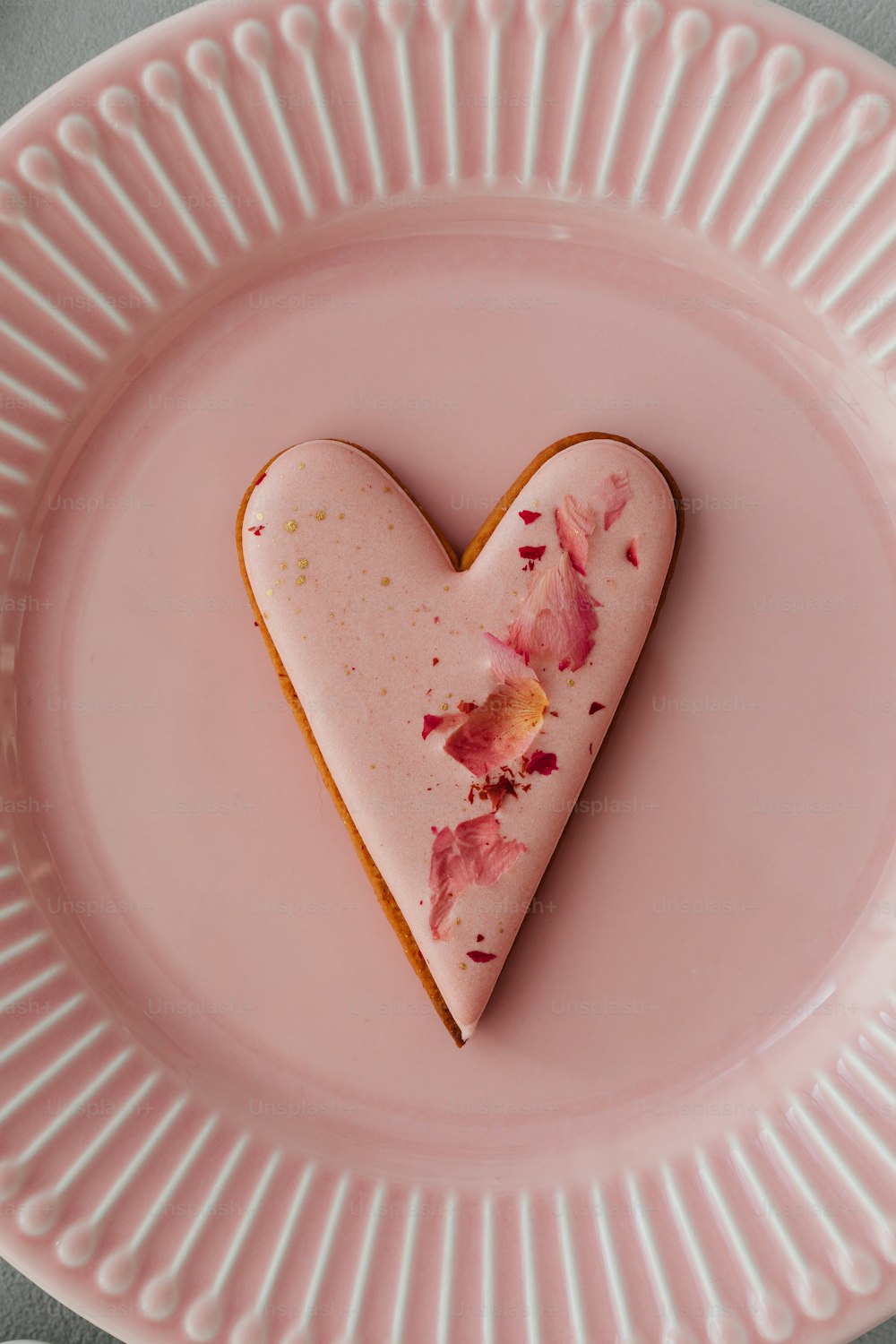 a heart shaped piece of food on a pink plate