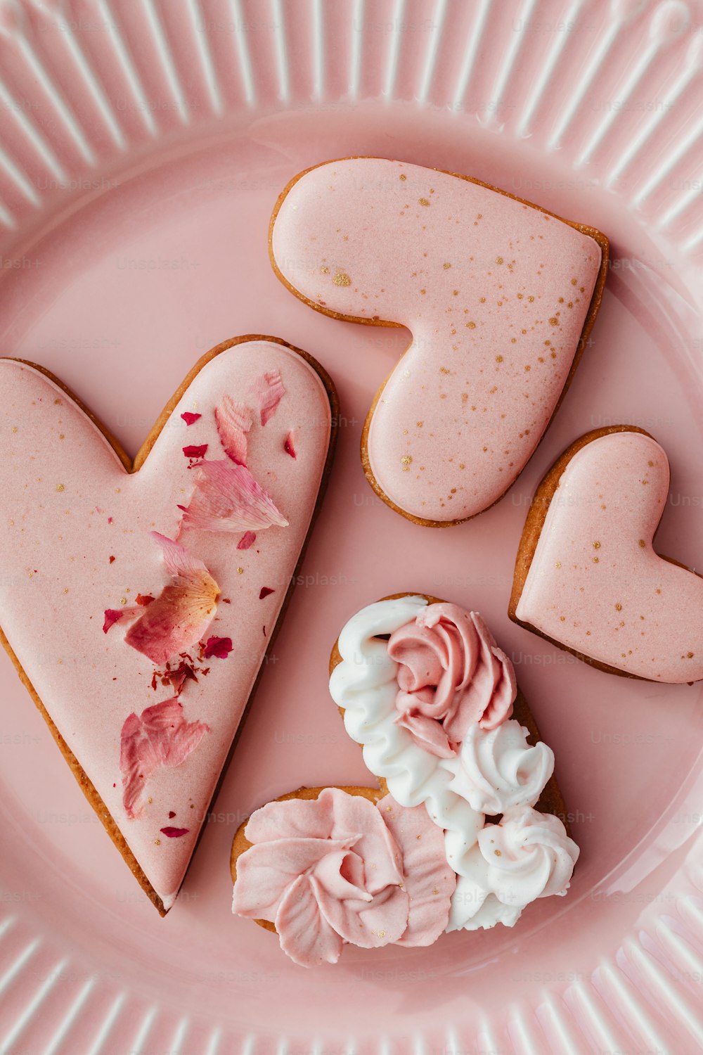 um prato rosa coberto com biscoitos em forma de coração