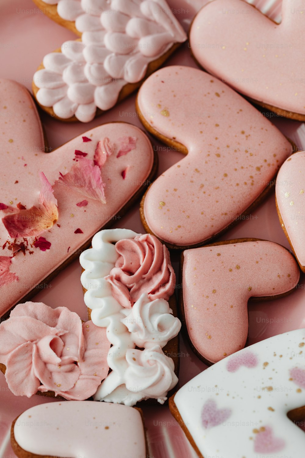 um prato rosa coberto com muitos biscoitos em forma de coração
