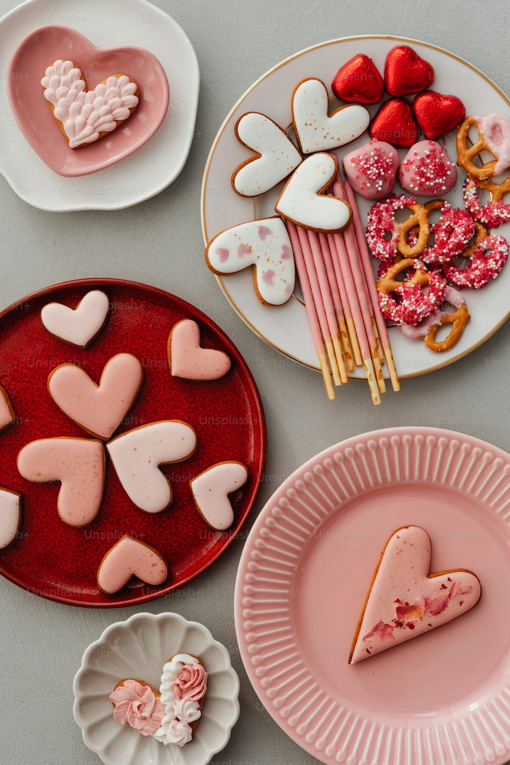 a table topped with plates of heart shaped cookies
