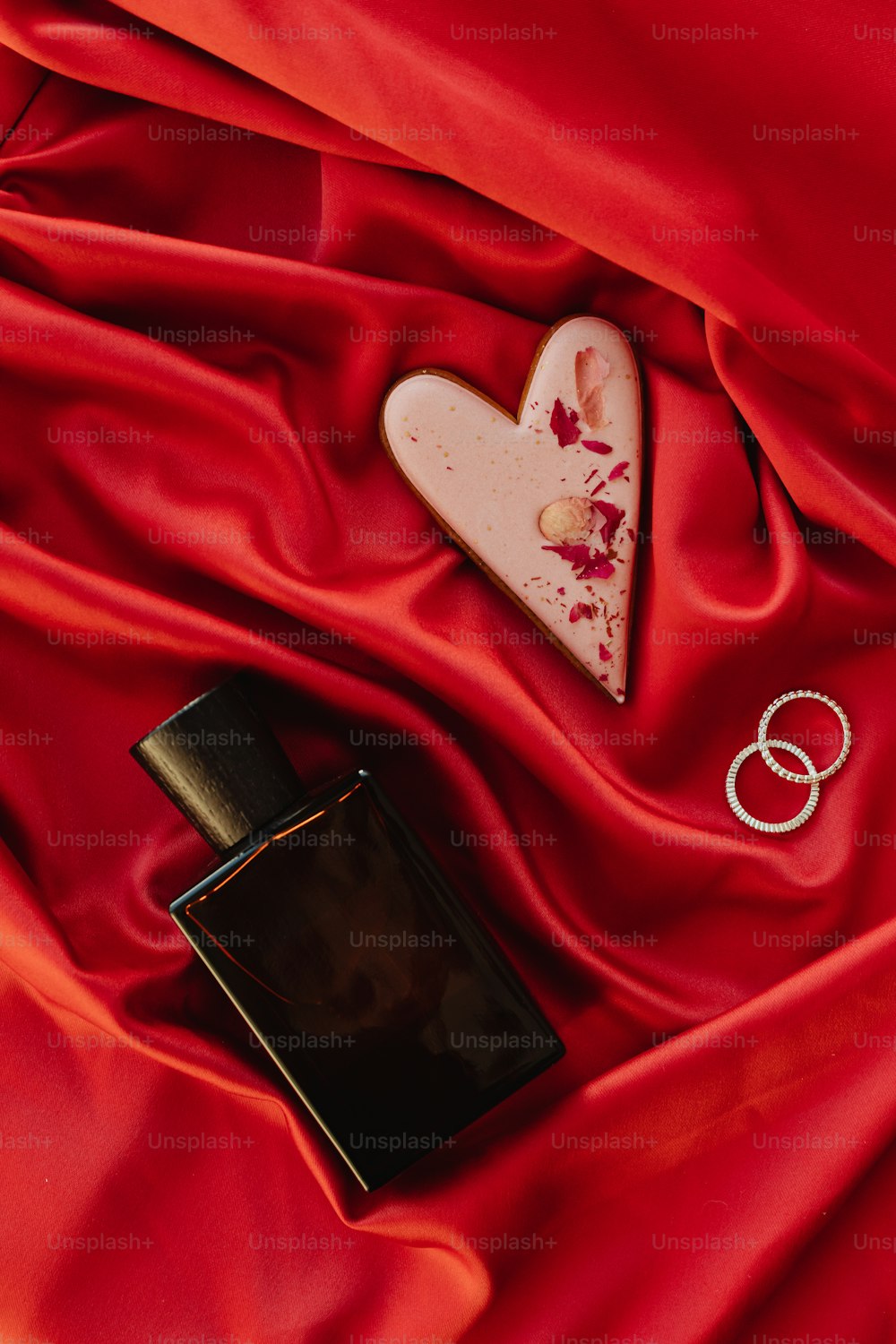 a picture of a ring and a heart on a red cloth