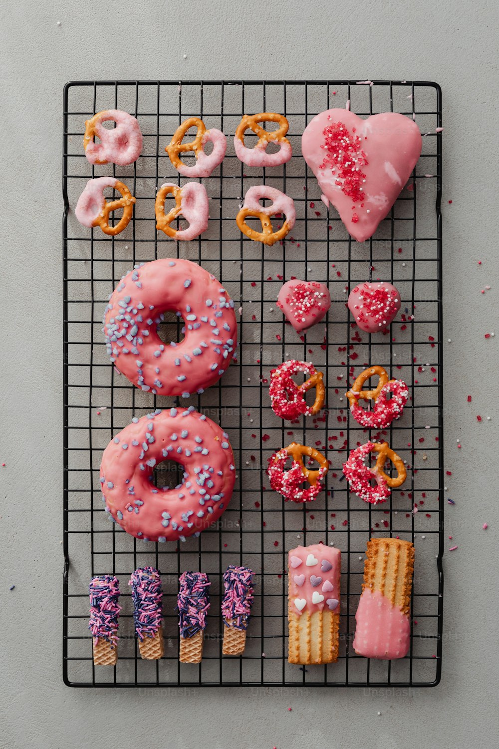 um rack de arame que contém uma variedade de donuts e pretzels