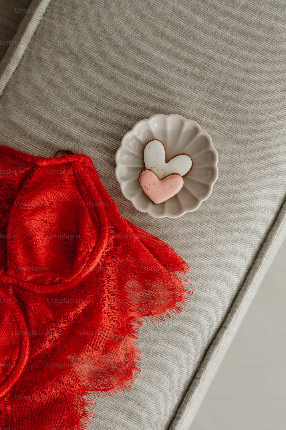 a heart shaped cookie sitting on a plate next to a red dress
