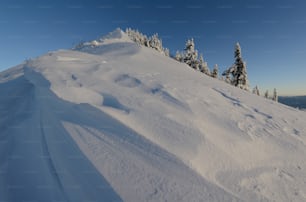 a person riding a snowboard down a snow covered slope