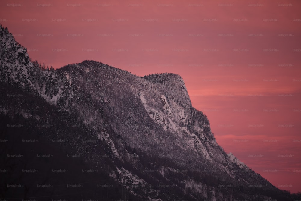 Una montaña con un cielo rojo en el fondo