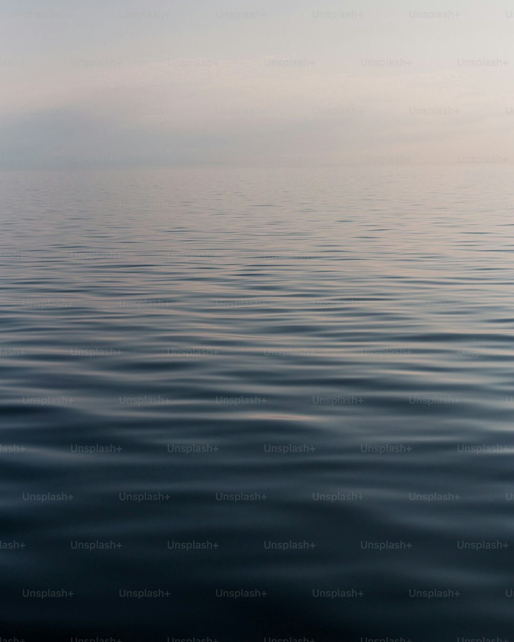 a large body of water with a sky in the background