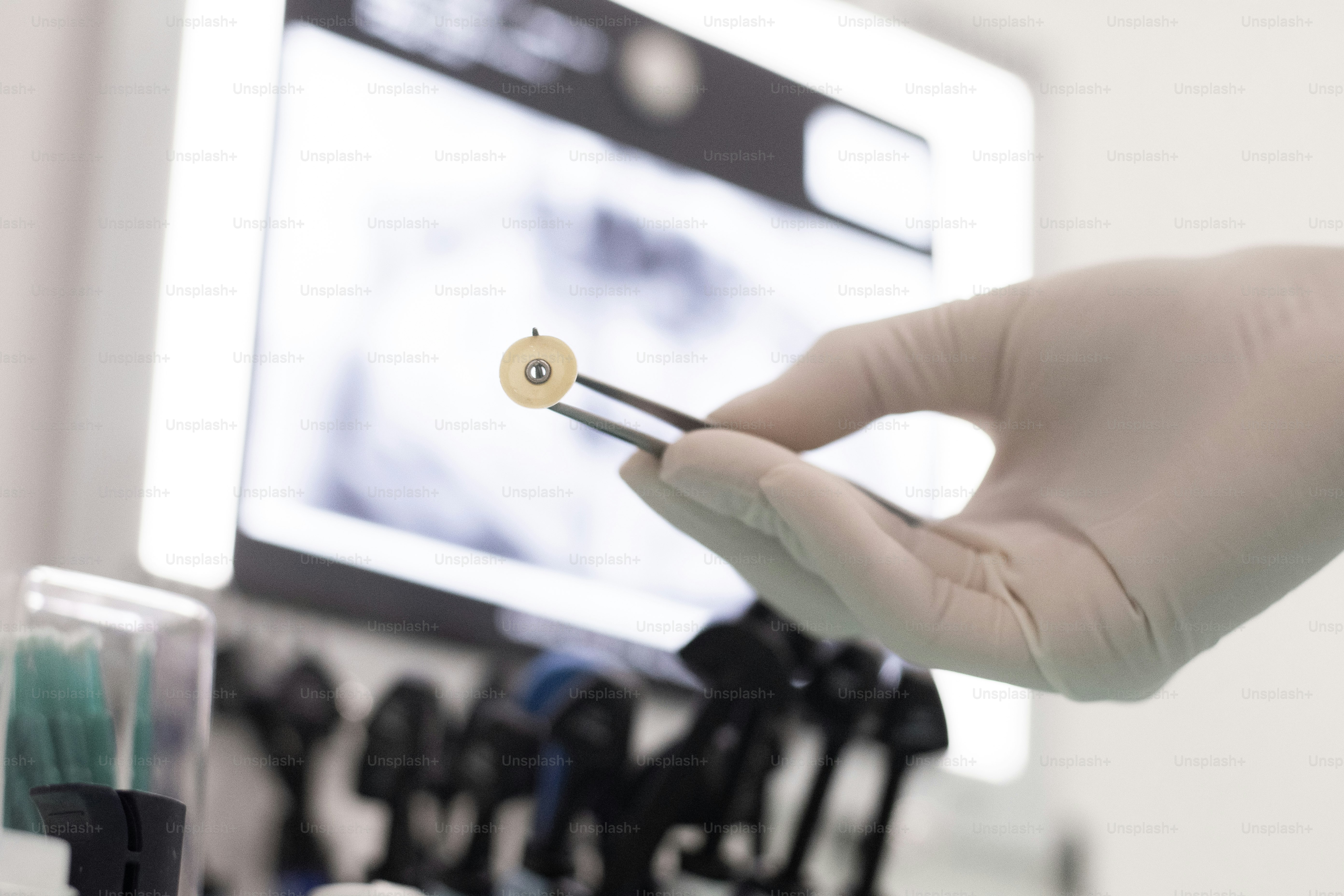 a person holding a small toothpick in front of a computer screen