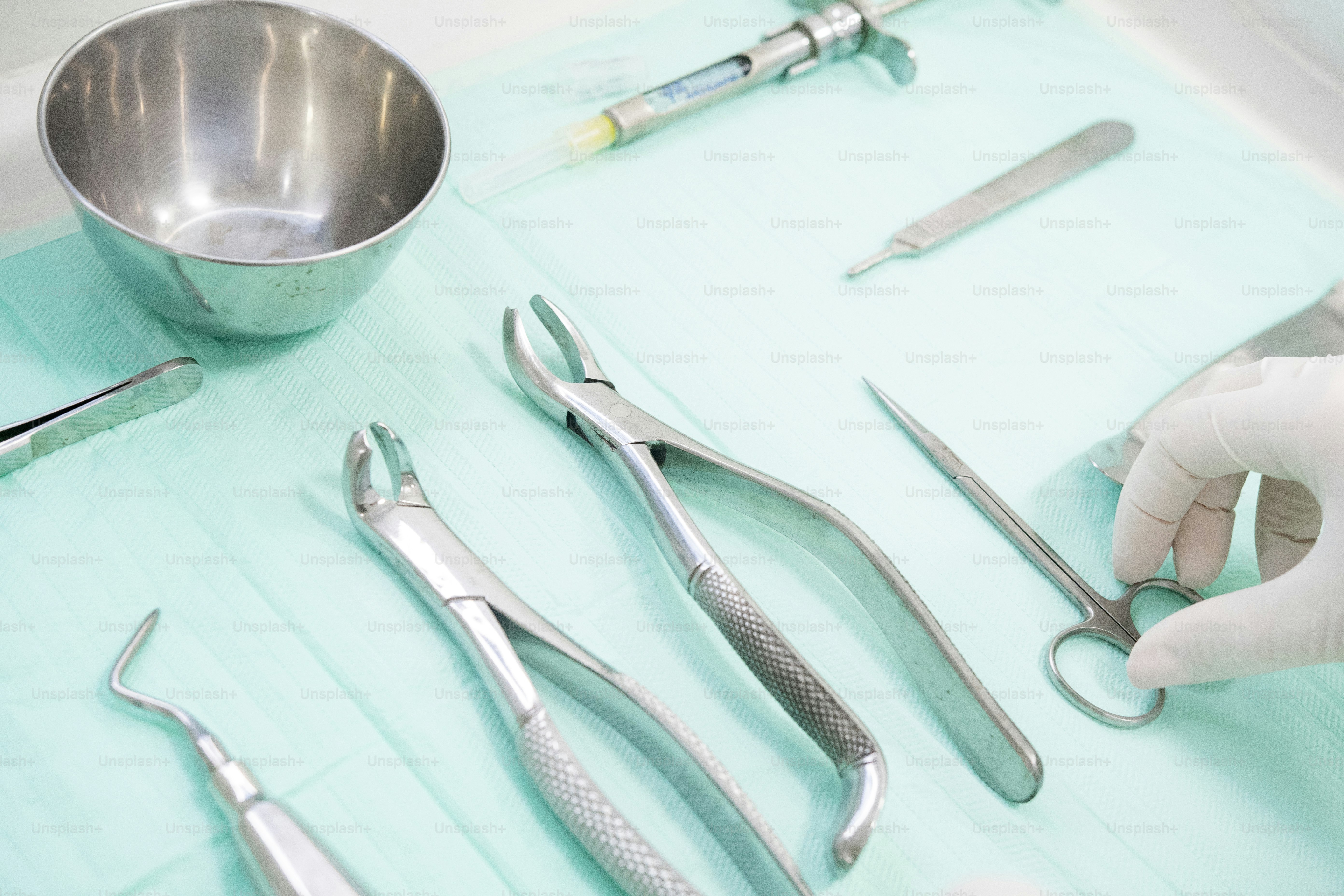 a table topped with surgical instruments and a bowl