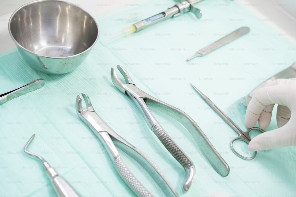 a table topped with surgical instruments and a bowl