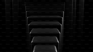 a row of black chairs in a dark room