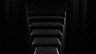 Eine Reihe schwarzer Stühle in einem dunklen Raum