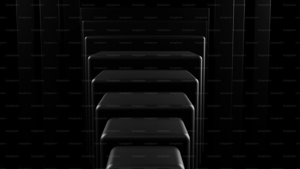 uma fileira de cadeiras pretas em um quarto escuro