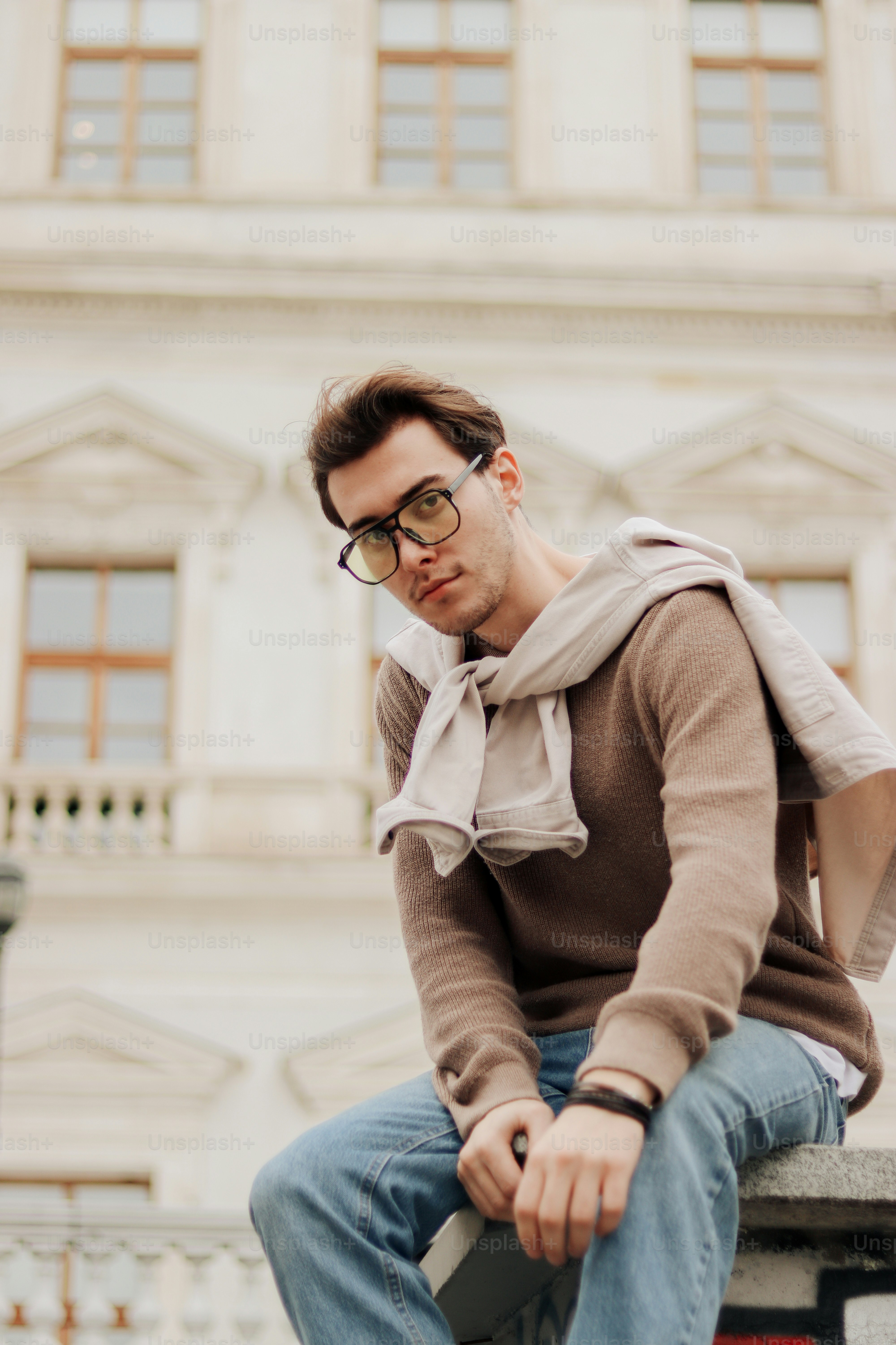 a man sitting on top of a cement bench