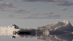 Una montagna coperta di neve accanto a uno specchio d'acqua